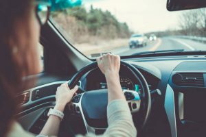 Femme les mains sur le volant d'une voiture en train de rouler