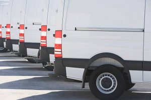 Plusieurs camionnettes blanches sur un parking