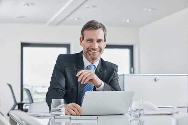 Homme d'affaires souriant derrière son bureau de travail