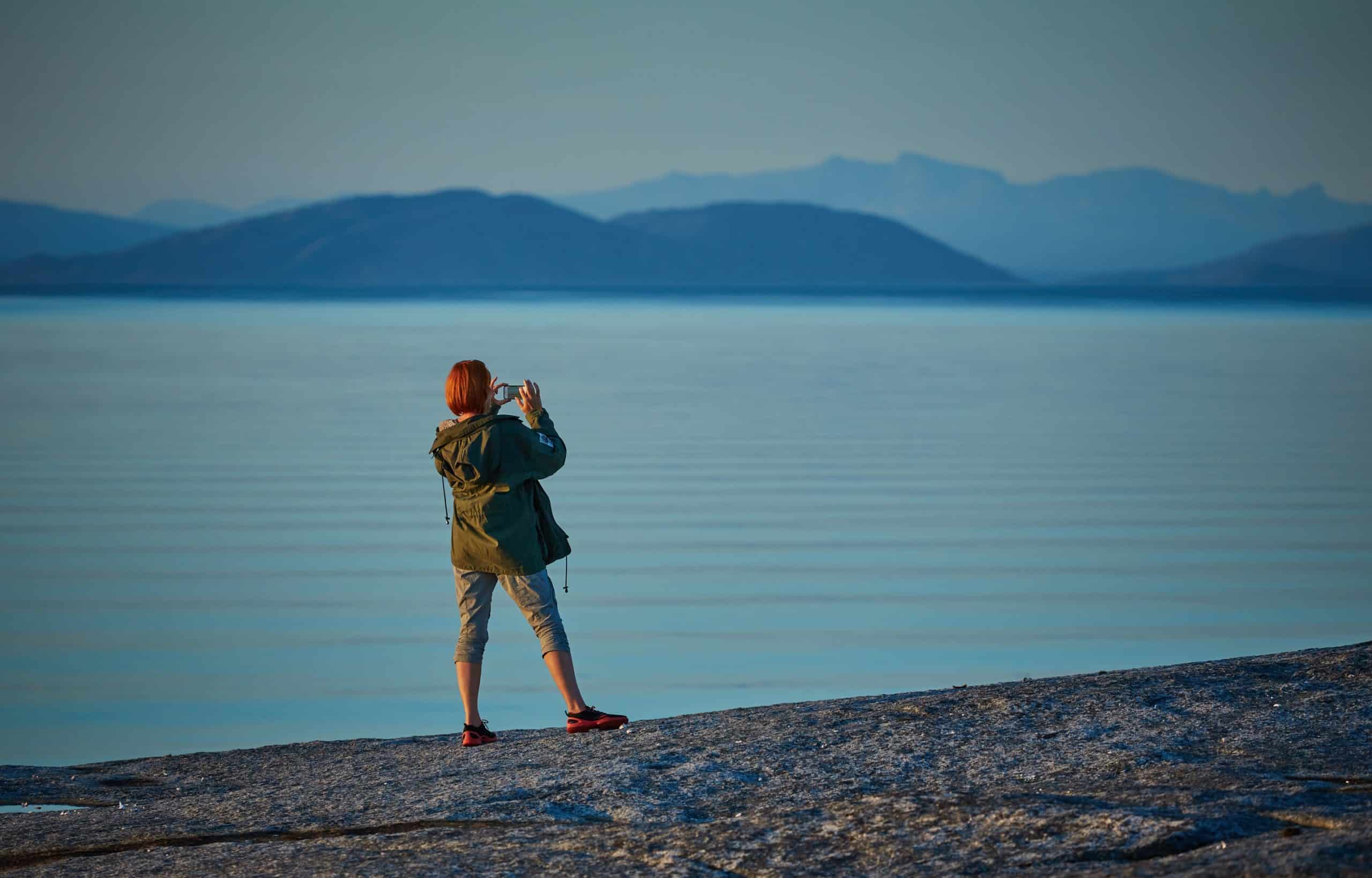 Une touriste prenant une photo avec son téléphone